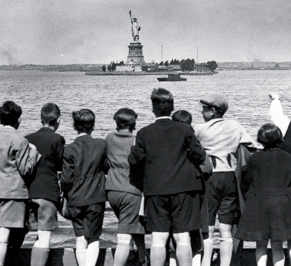 Children aboard the President Harding look at the Statue of Liberty as they pull into New York Harbor.