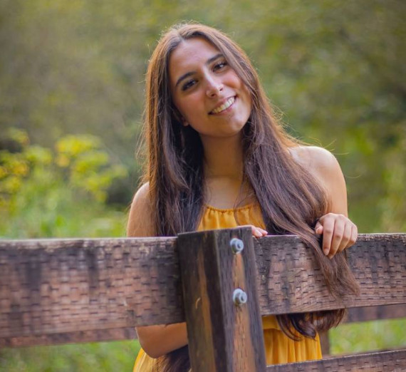 Gonzaga Senior Antoinne Herrbach, smiling next to close up of globe.