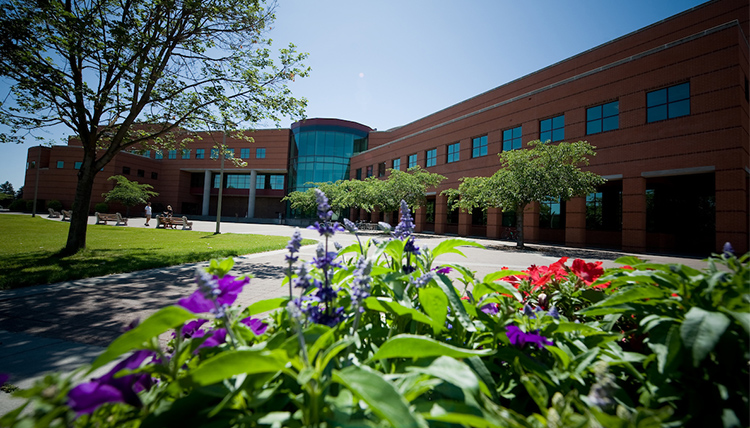 Image of flowers in front of Foley Center Library on a sunny day