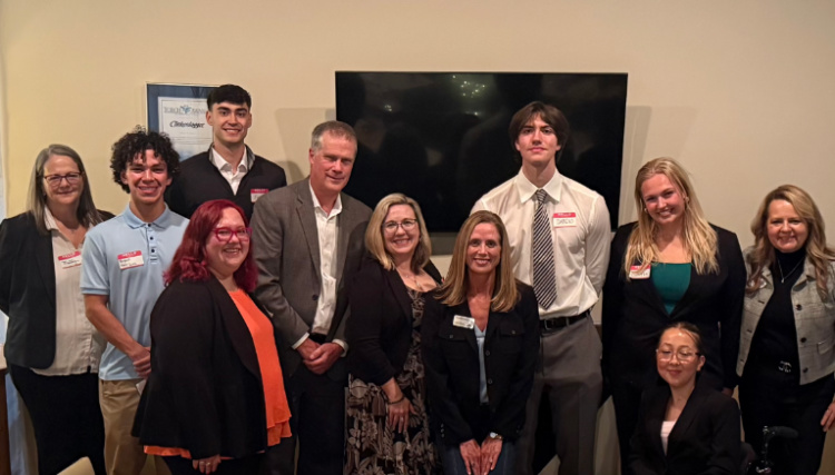 Woman in a t-shirt with a star on it leans against a railing