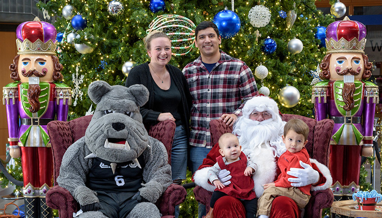 Family poses with Santa and Spike at Gonzaga Alumni Advent Mass & Photo with Santa and Spike