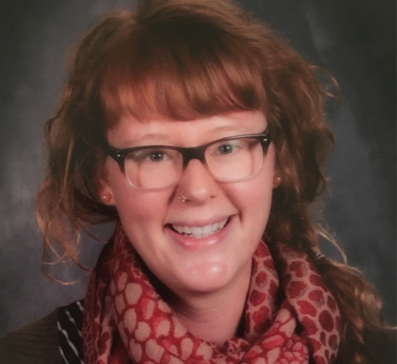 Alumna Melissa Koontz, class of 2012, sits at desk