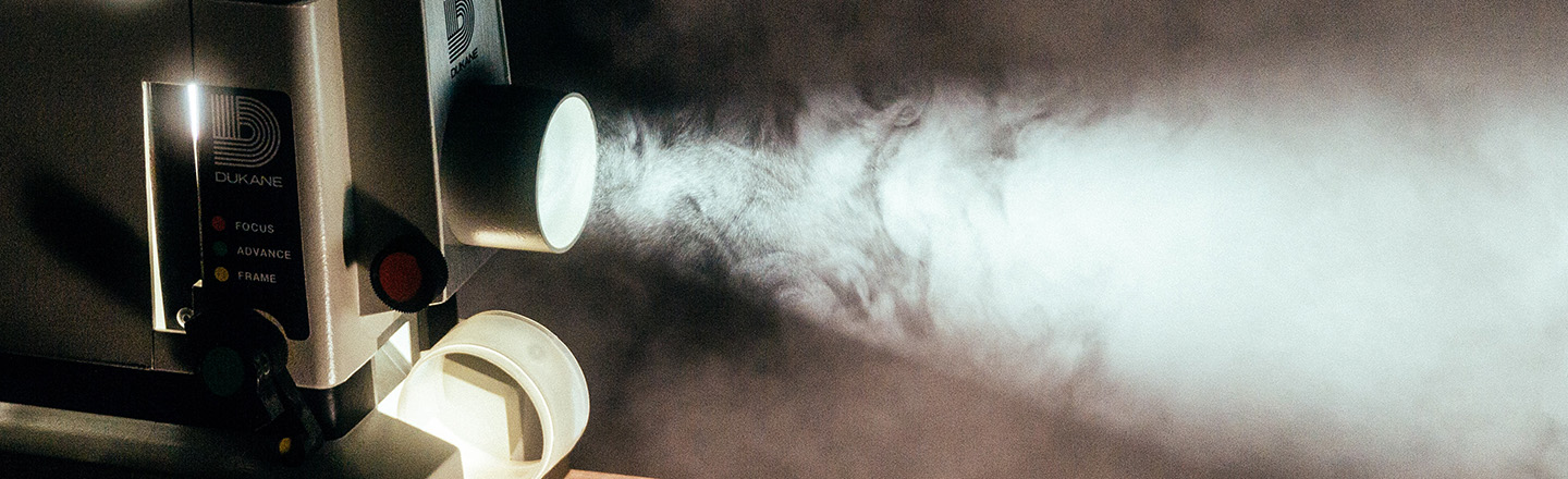Vintage film camera projecting through white smoke.