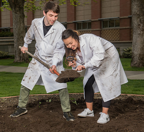 Students dig in dirt. 