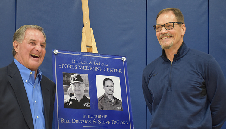 Bill Diedrick and Steve DeLong stand with old photos of them during a dedication ceremony