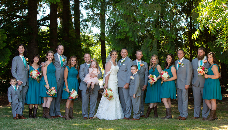 large wedding party with women in teal dresses and men in gray suits