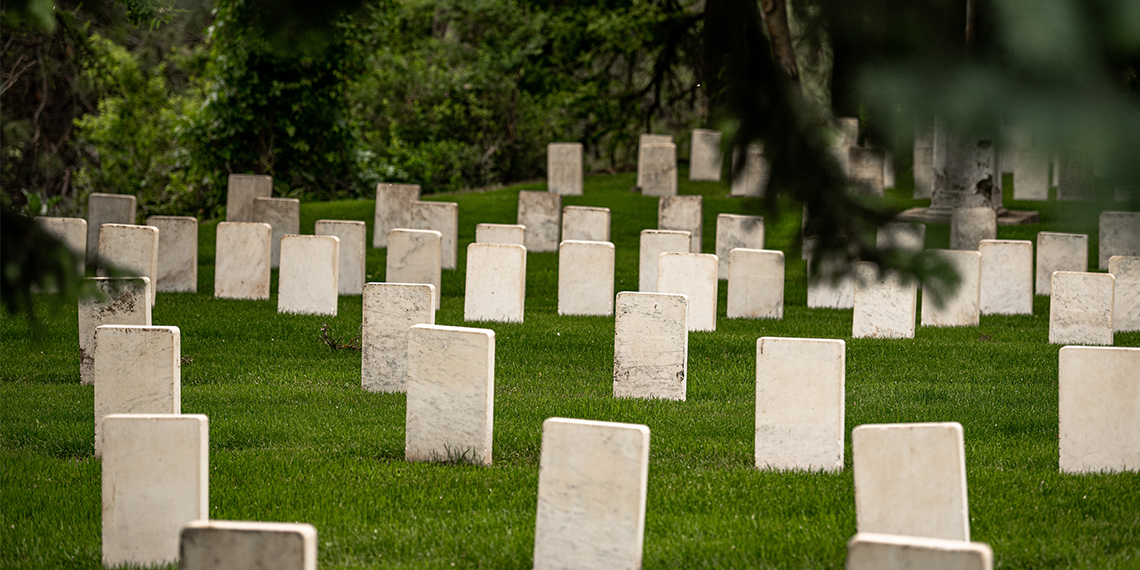 rows of old headstones in graveyard