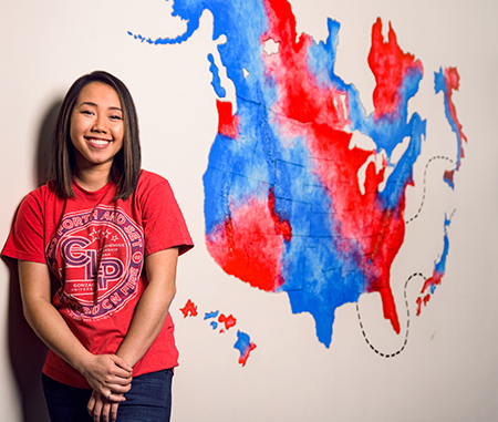 Cat Truong (’14) in front of the mural she created in Gonzaga's advancement office. (Photo by Zack Berlat)
