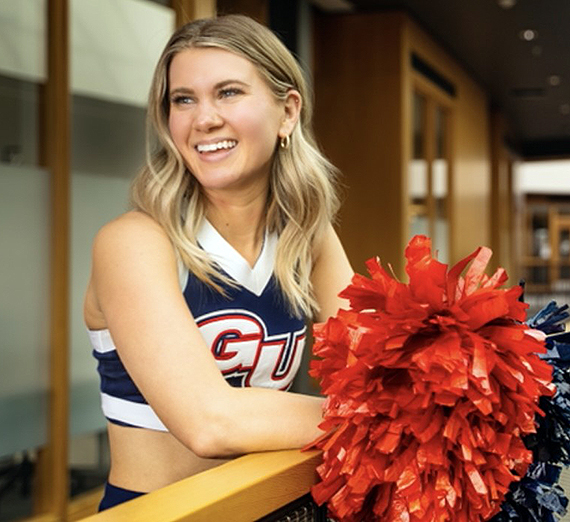 A woman jumps and cheers in a crowd of students
