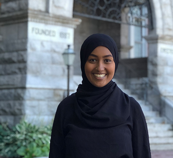 Gonzaga Senior Antoinne Herrbach, smiling next to close up of globe.