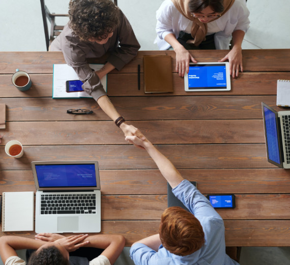 A woman with blond hair hands a Christmas stocking to a woman with long brown hair