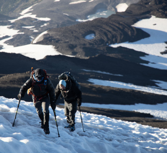 two individuals climbing snowy mountain 