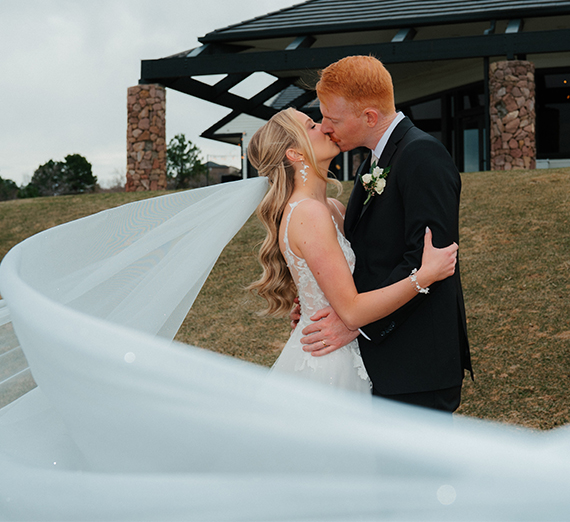 Hoeing and Rossi holding a Gonzaga flag at their wedding with guests.