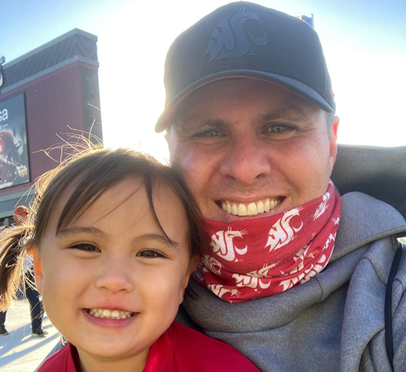 Woman in red Gonzaga t-shirt among fans cheering at basketball court