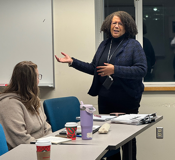 A woman stands at a white board in a classroom A woman stands at a white board in a classroom