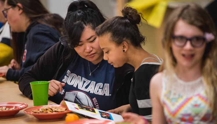 female college student talks with younger primary student female college student talks with younger primary student