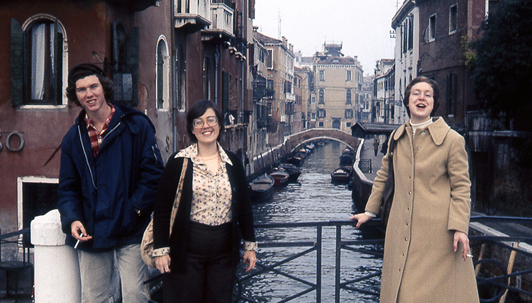 A group of three students smiling together on a bridge in Venice, Italy. A group of three students smiling together on a bridge in Venice, Italy.