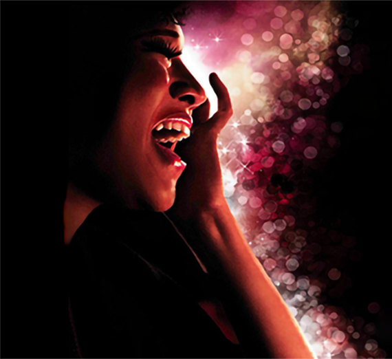 A close up of an artist's face as they sing passionately, against a sparkling pink and black background.