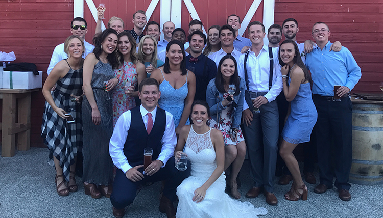 couple surrounded by friends in front of barn couple surrounded by friends in front of barn