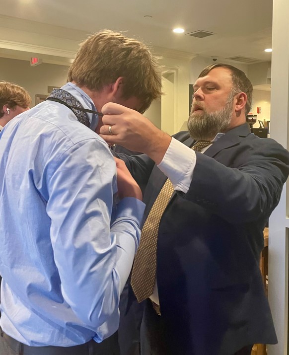 Student getting help tying his tie from a Gonzaga staff member. Student getting help tying his tie from a Gonzaga staff member.