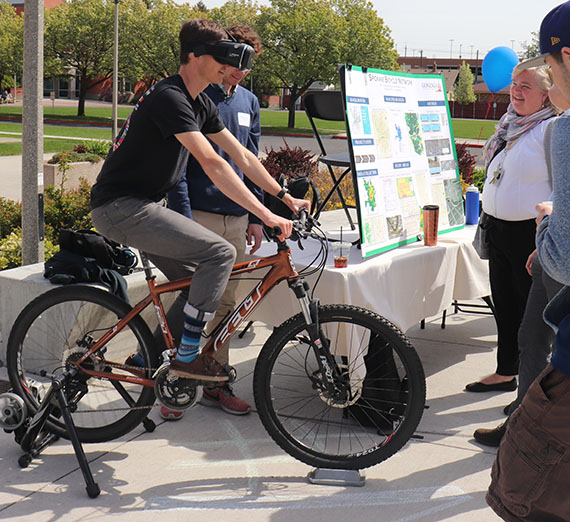 young person wearing virtual reality headset while on a stationary bicycle