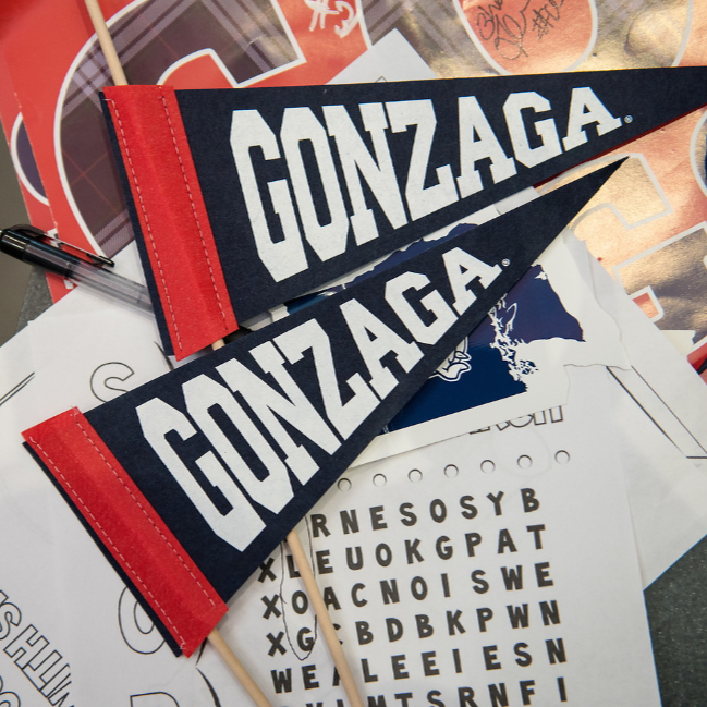 Two Gonzaga pennants one above the other in the picture. The two pennants have a red lining on the left-hand side and are navy blue with white letters spelling out 