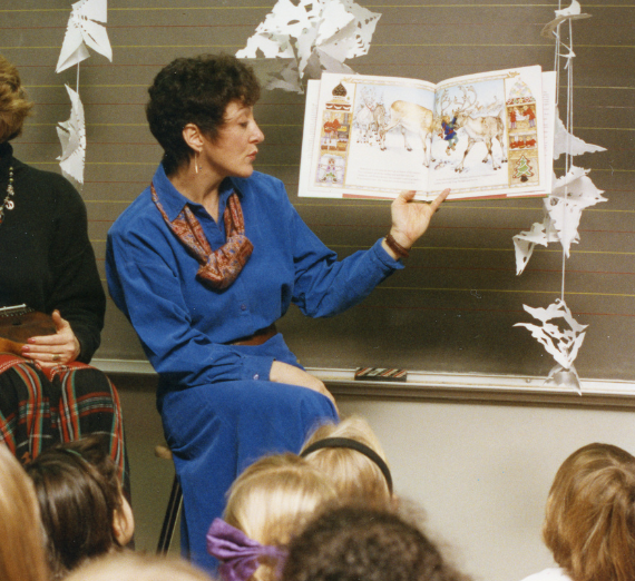 Dr. Nieding holds up a picture book to read to children.