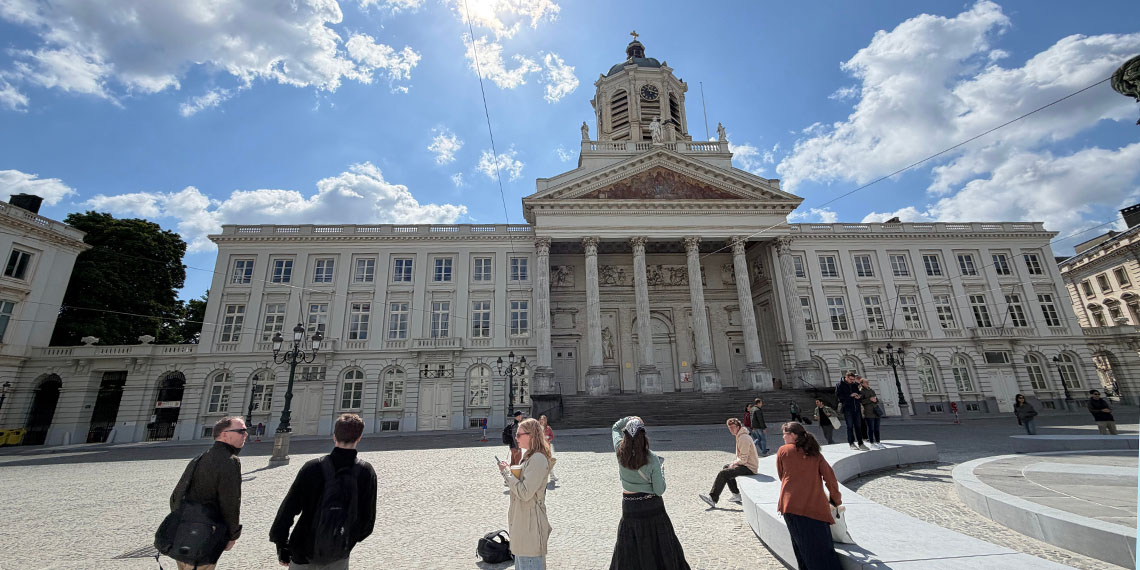 Distorted perspective view of a large old building with tall pillars and a bell tower