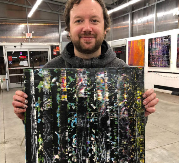 scholarship-jimmy-magnuson-painting Jimmy holding up a painting.