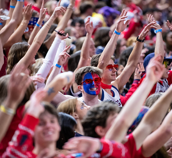 students with arms raised