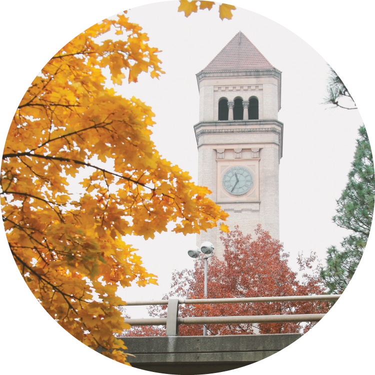 A sweep of autumn-orange leaves frame the edge of the photo with the Spokane clock tower behind. A sweep of autumn-orange leaves frame the edge of the photo with the Spokane clock tower behind.