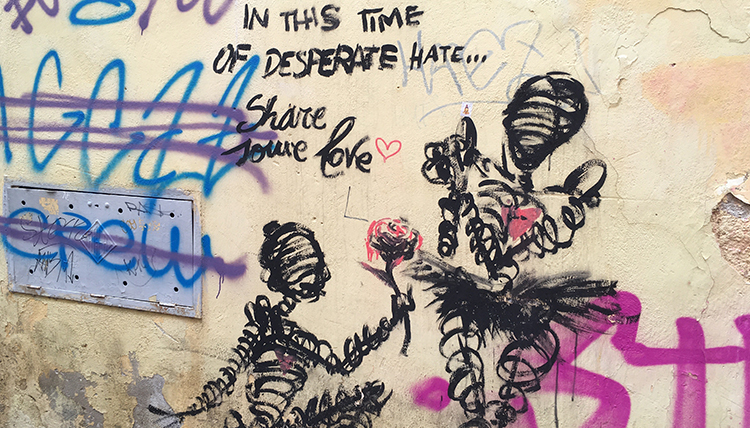 graffiti of a person kneeling, offering a rose to another person