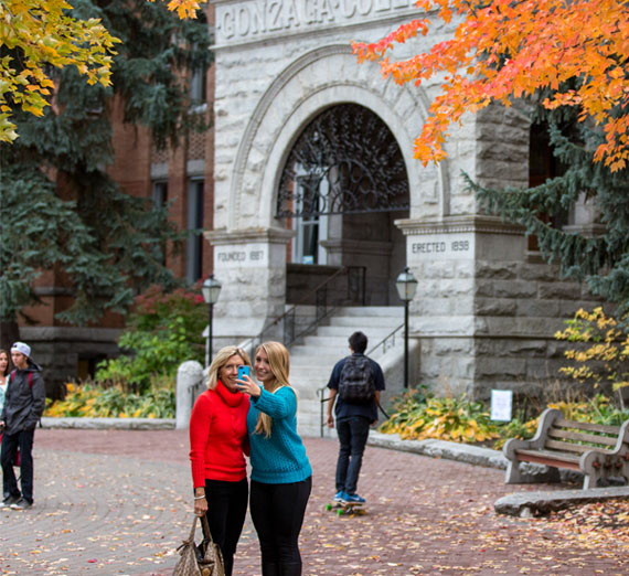 student and parent take picture in front of college hall 