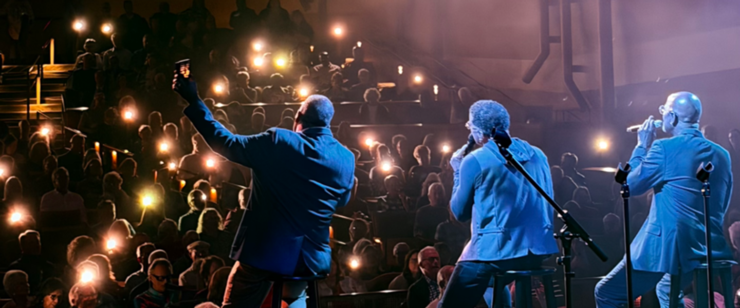 From the viewpoint of the Myrtle Woldson Performing Arts Center stage, musicians perform for a packed audience. 