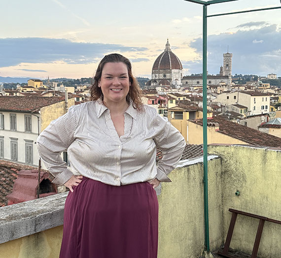 Woman wearing white button up and burgundy maxi skirt standing with views of Florence, Italy in the background Woman wearing white button up and burgundy maxi skirt standing with views of Florence, Italy in the background