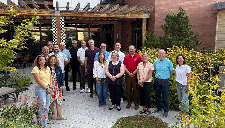 a group of men and women meet outside a residence in the summertime a group of men and women meet outside a residence in the summertime