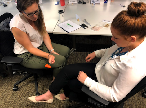 Claire Henson testing her fellow intern Erin Hayes' reflexes. Claire Henson testing her fellow intern Erin Hayes' reflexes.