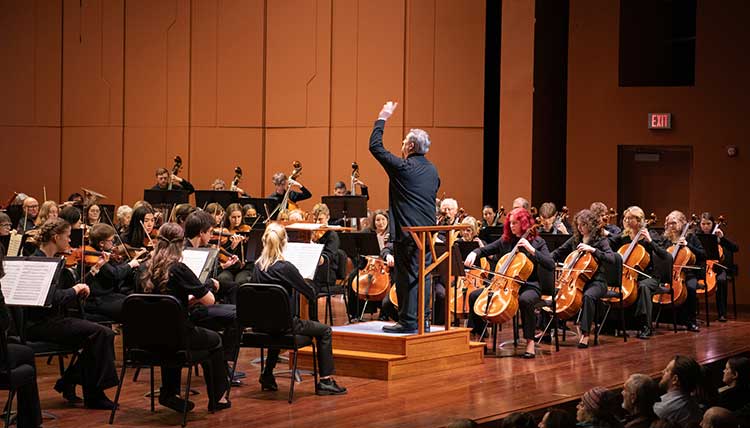 orchestra-concert-2026 Full orchestra with conductor on a large stage