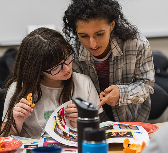 A teacher reads with a student.