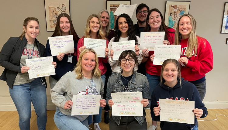 School Counseling students hold up pieces of paper with their hopes written on them School Counseling students hold up pieces of paper with their hopes written on them