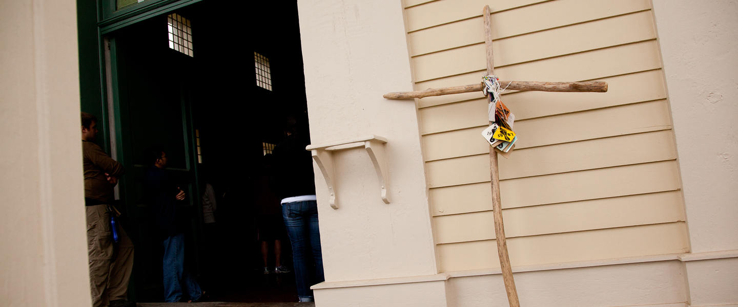 A large wood cross rests against a church after a pilgrimage