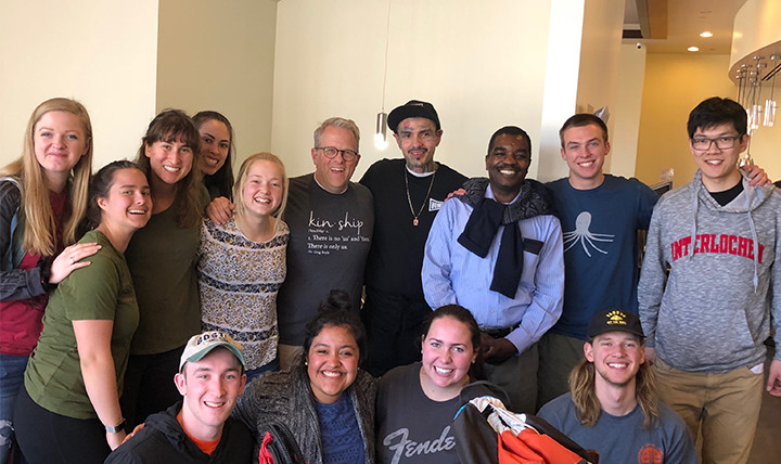 A group of men and women - students, a professor, a priest, and an employee at Homegirl Café - smile for a photo at Homeboy Industries A group of men and women - students, a professor, a priest, and an employee at Homegirl Café - smile for a photo at Homeboy Industries