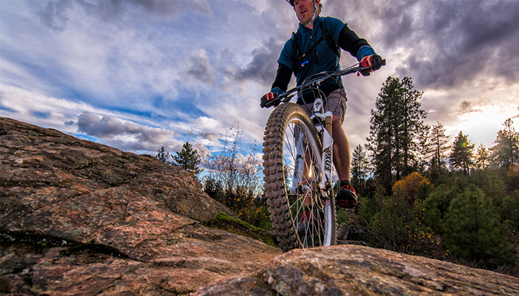 A mountain biker crosses a rocky section of trail. A mountain biker crosses a rocky section of trail.