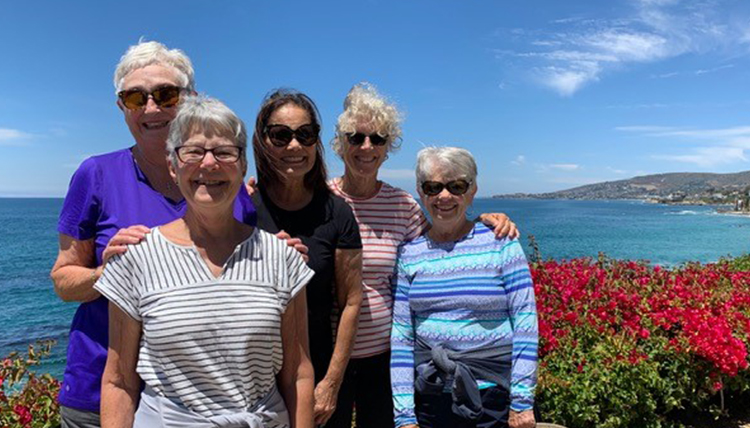 five women standing near the ocean five women standing near the ocean