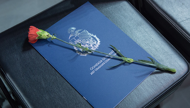 A program and rose in a chair at the 2017 Commencement ceremony A program and rose in a chair at the 2017 Commencement ceremony