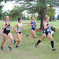 4 female athletes running. 4 female athletes running.