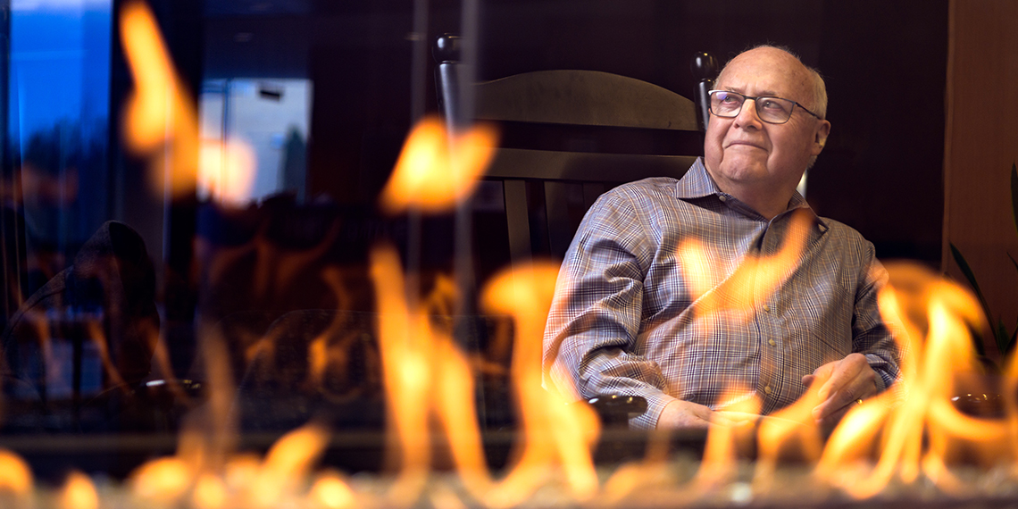 Blaine Garvin sits next to the Hemmingson fireplace.