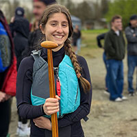 sq-engineering-student-paddle Smiling student wearing a blue life vest and holding a boat paddle