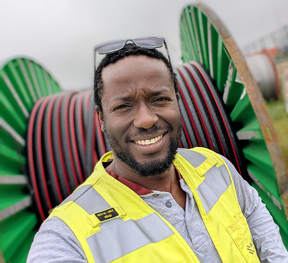 Man wearing high visibility vest smiling and taking a selfie