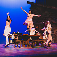 Three dancers performing on stage. Three dancers performing on stage.